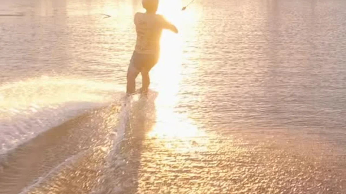 Rider andando ao pôr do sol no lago do Wake Park Palmeiras, em Uberlândia
