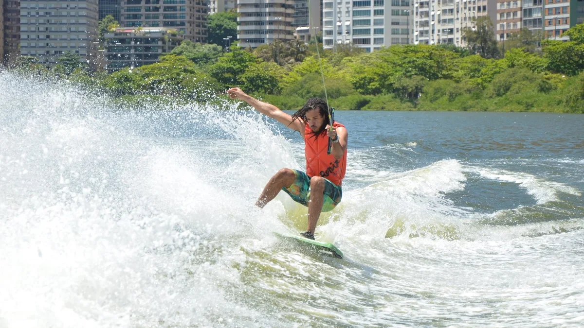 Rider de wakeboard em ação na Lagoa Rodrigo de Freitas, com o skyline do Rio ao fundo