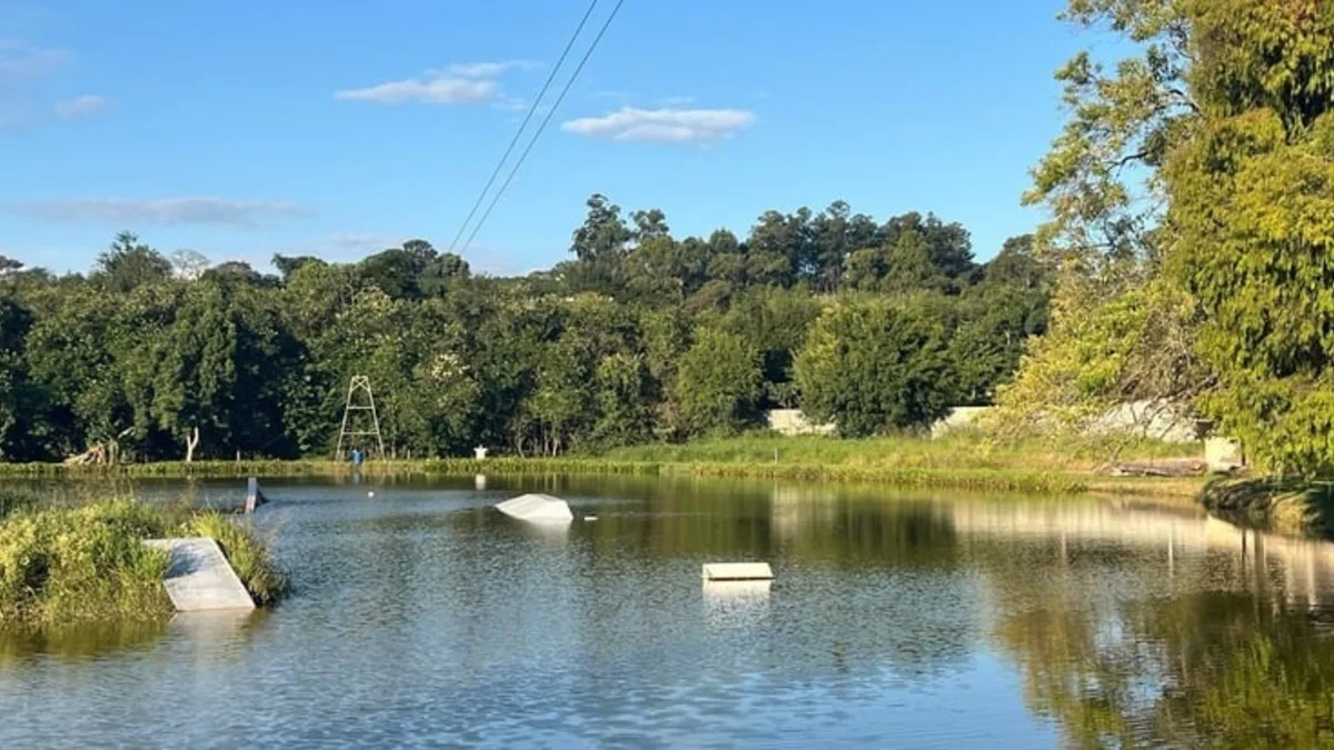 Lago do Sítio Paulista Cable Park com a torre do cabo e obstáculos de wakeskate